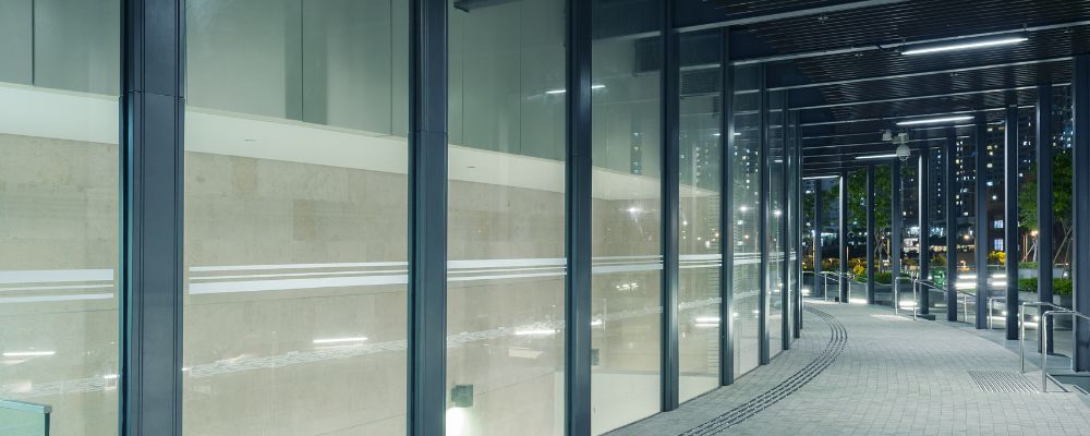 Exterior of modern offices with large glass wall and several types of LED lighting visible