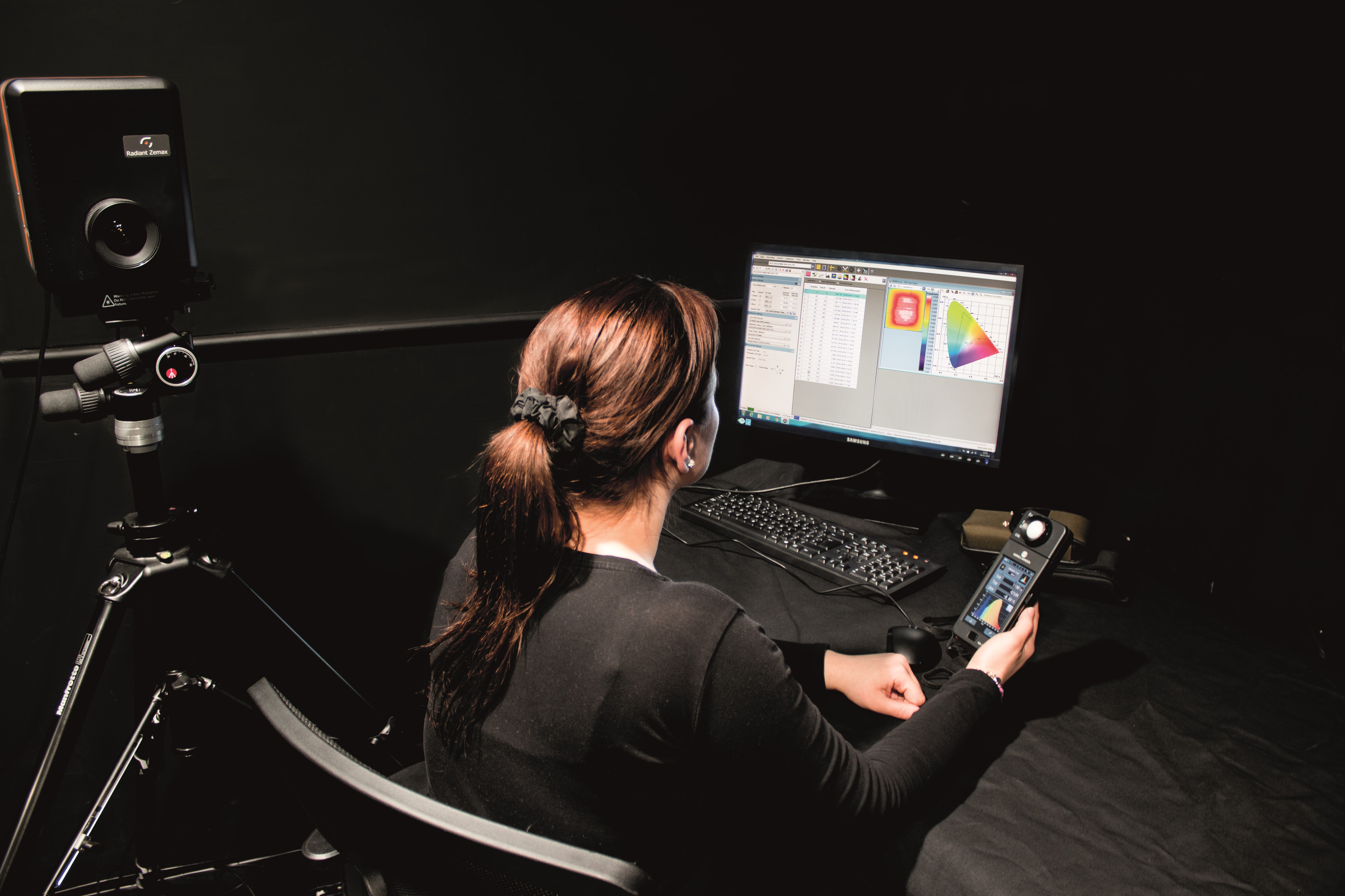 Woman looking at graphical lighting data on a computer