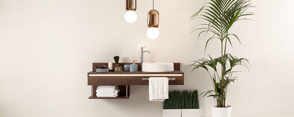 Minimalist bathroom sink / vanity unit with strip lighting on the front, lifestyle accessories and distinctive pendants